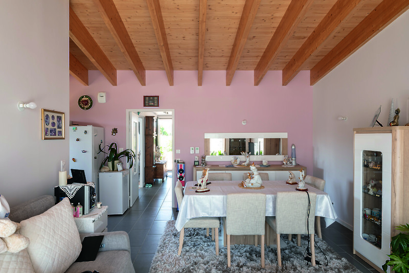 Dans le séjour, le haut plafond et les poutres en bois apparentes apportent une sensation d’espace et une ambiance chaleureuse. © Ludmilla Cerveny
